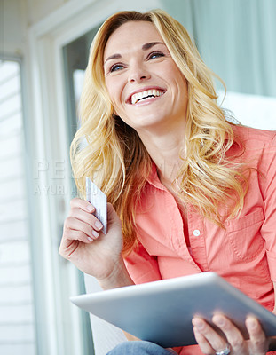 Buy stock photo Cropped shot of a beautiful young woman using her digital tablet and credit card to shop online