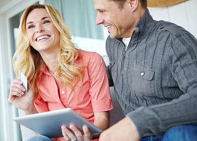 Buy stock photo Cropped shot of a happy mature couple using a digital tablet to shop online together at home