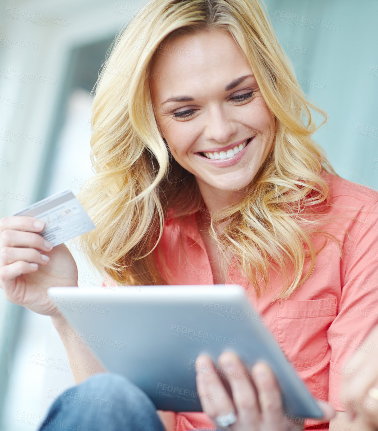 Buy stock photo Cropped shot of a beautiful young woman using her digital tablet and credit card to shop online