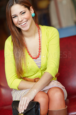 Buy stock photo A fashionable young woman sitting on a chair inside a fashion store