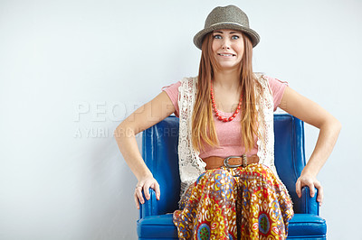 Buy stock photo Portrait of a quirky woman in vintage clothing on a blue armchair. A stylish young brunette in trendy thrifted clothing with a silly facial expression, looking worried. Fashion model in retro style