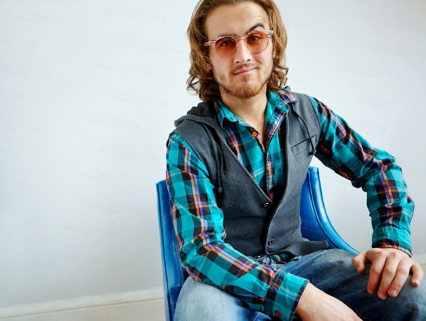 Buy stock photo A handsome young guy wearing a trendy outfit sitting on an armchair indoors