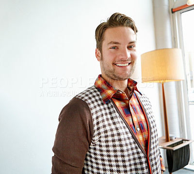 Buy stock photo A handsome young man in a trendy outfit smiling while standing in a home interior