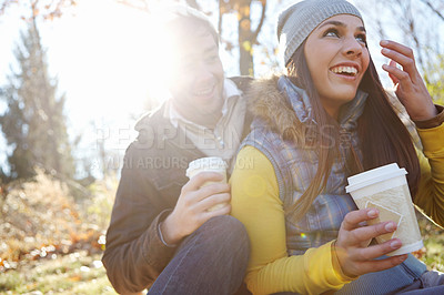 Buy stock photo Couple, laughing and relax with coffee in nature for bonding, funny joke and winter adventure with lens flare. People, happy and caffeine drink in forest on holiday, vacation or fun together in woods