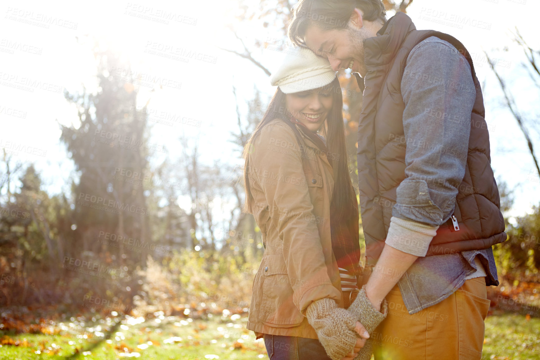 Buy stock photo Couple, smile and love with affection in forest for outdoor adventure, break and happy on weekend. Man, woman and romance with hug in sunshine for morning, anniversary or camp together in New Zealand