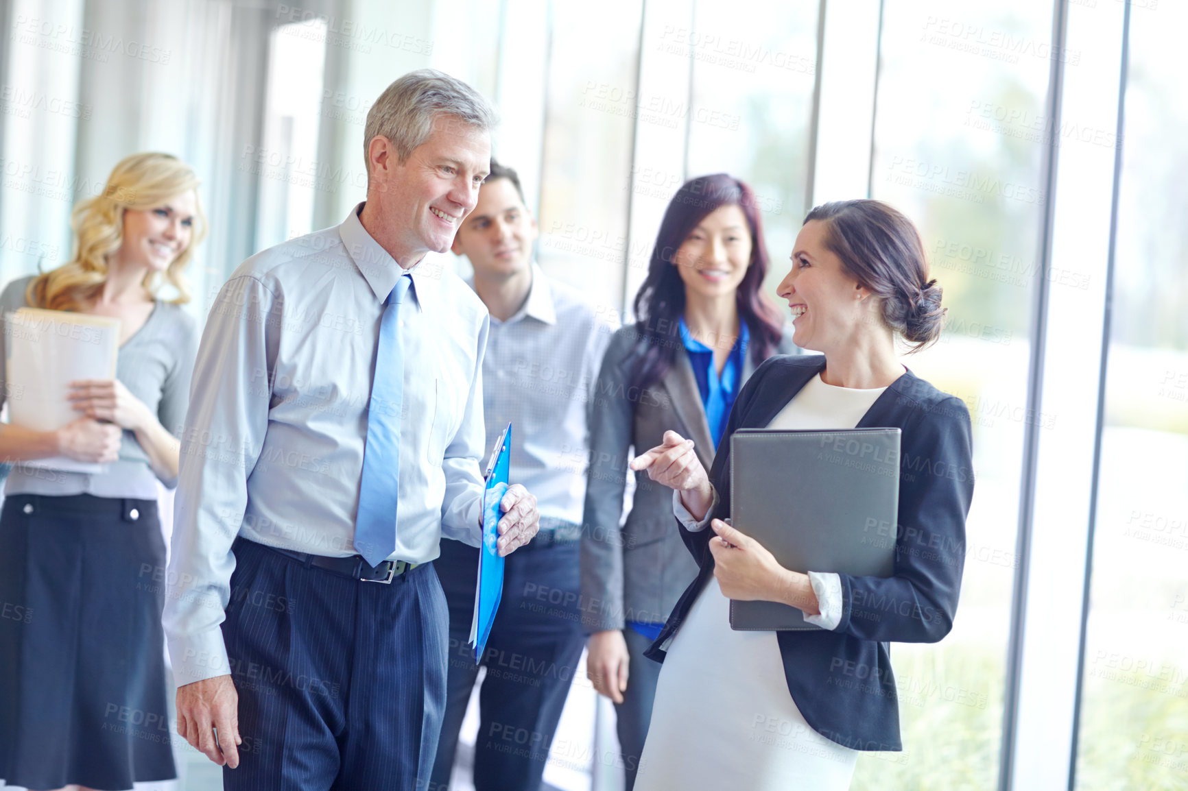 Buy stock photo People, meeting and happy in lobby for business, introduction and office walkthrough. Receptionist, investors and notes in corporate building for collaboration, finance opportunity or company funding