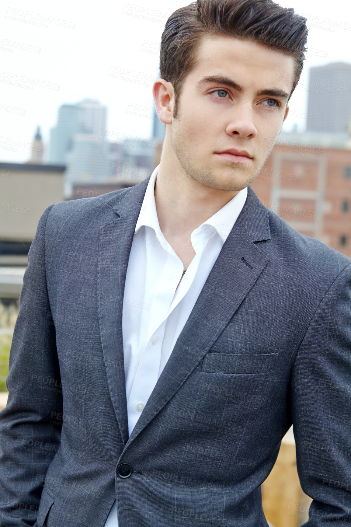 Buy stock photo A handsome young man in a stylish blazer standing against a cityscape