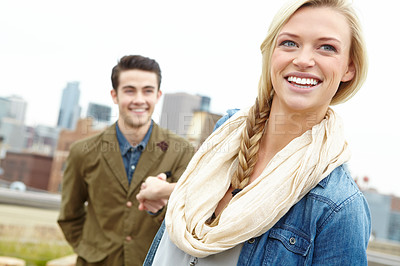 Buy stock photo A young woman smiling while leading her boyfriend by the hand