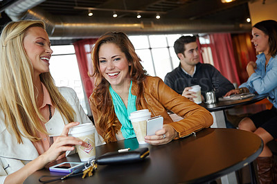 Buy stock photo Two attractive young women having coffee together 
