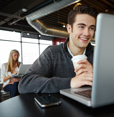 Buy stock photo A handsome young man using his laptop in a coffee shop