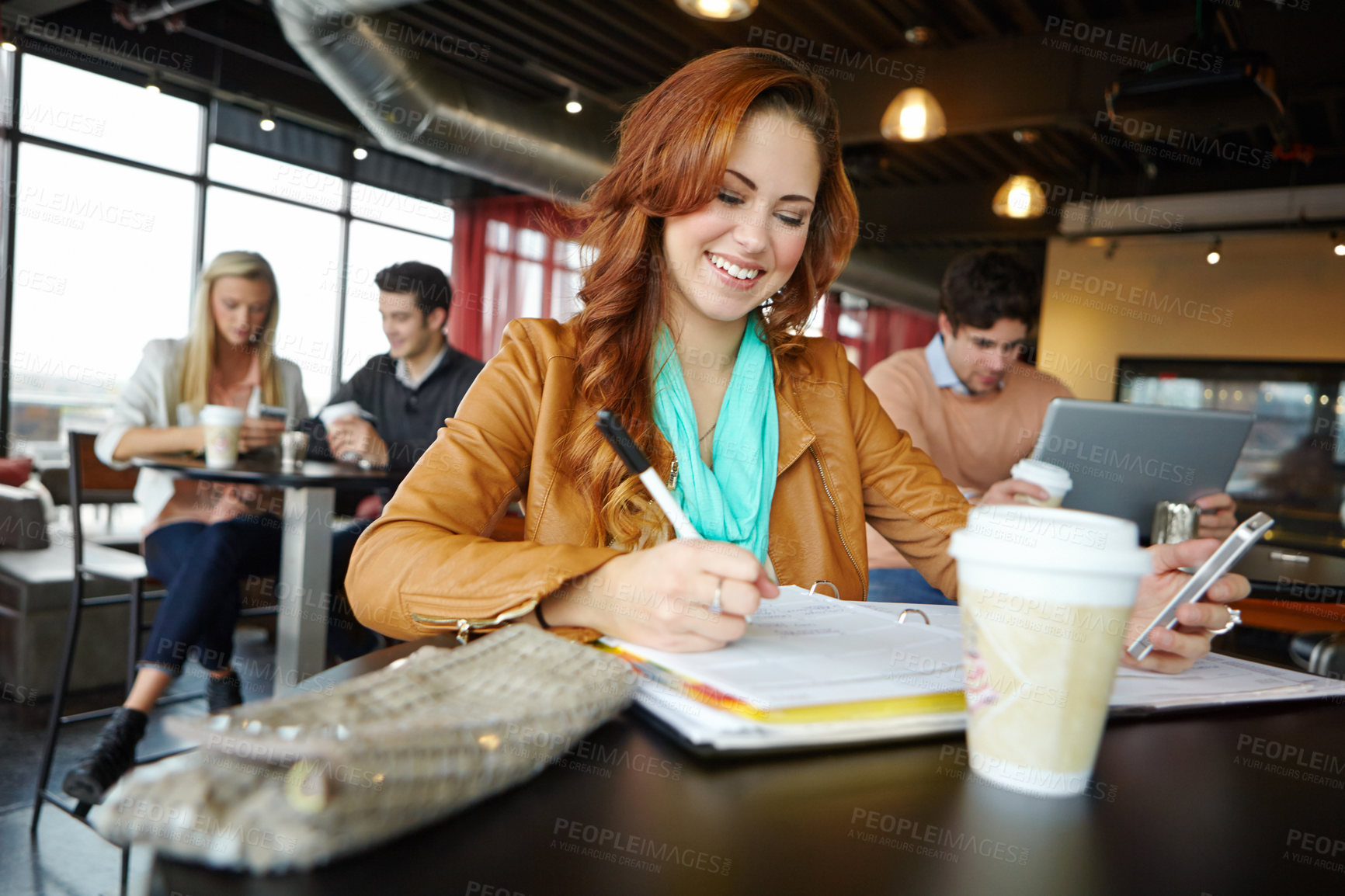 Buy stock photo A beautiful young university student using her smartphone in a coffeee shop while studying