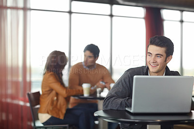 Buy stock photo A handsome young man using his laptop in a coffee shop