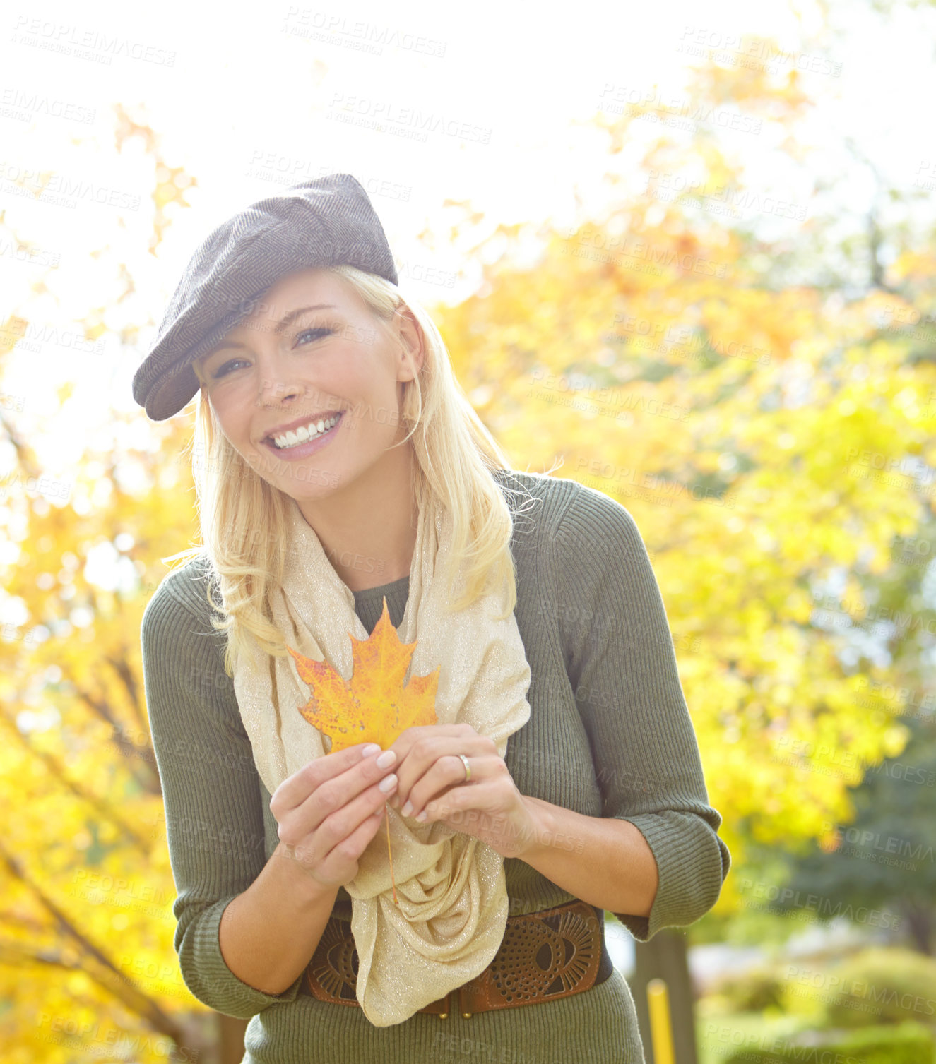 Buy stock photo Woman, face and leaf in park during autumn season for leisure, joy and playful outdoor on holiday. Female person, portrait and trees in nature in fall weather for travel, vacation and positive mood