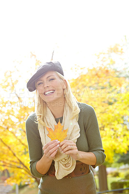 Buy stock photo Female person, happy and leaf in park during autumn season for leisure, joy and playful outdoor on holiday. Woman, portrait and smile in nature in fall weather for travel, vacation and positive mood