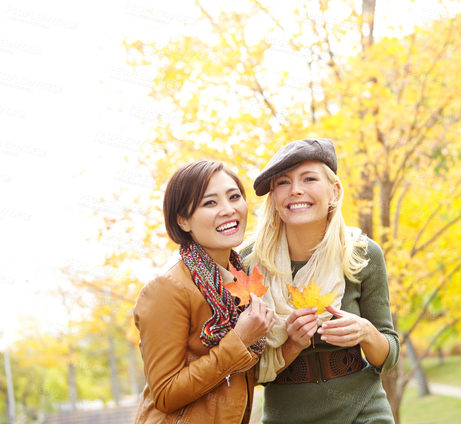 Buy stock photo Friends, portrait and women with leaves in autumn for outdoor adventure, environment or season change. Happy, people and smile with foliage in park for holiday, travel or vacation together in Germany