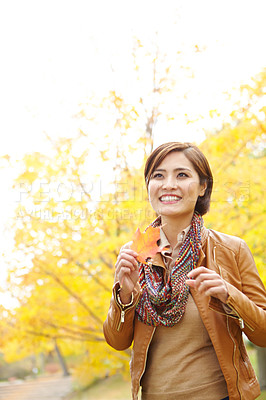 Buy stock photo Woman, autumn and smile with leaf in park with thinking, sustainability and wonder in nature. Korean person, thoughtful and daydreaming with plant foliage in outdoor environment with relax and happy