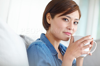 Buy stock photo An attractive Asian woman enjoying a cup of coffee