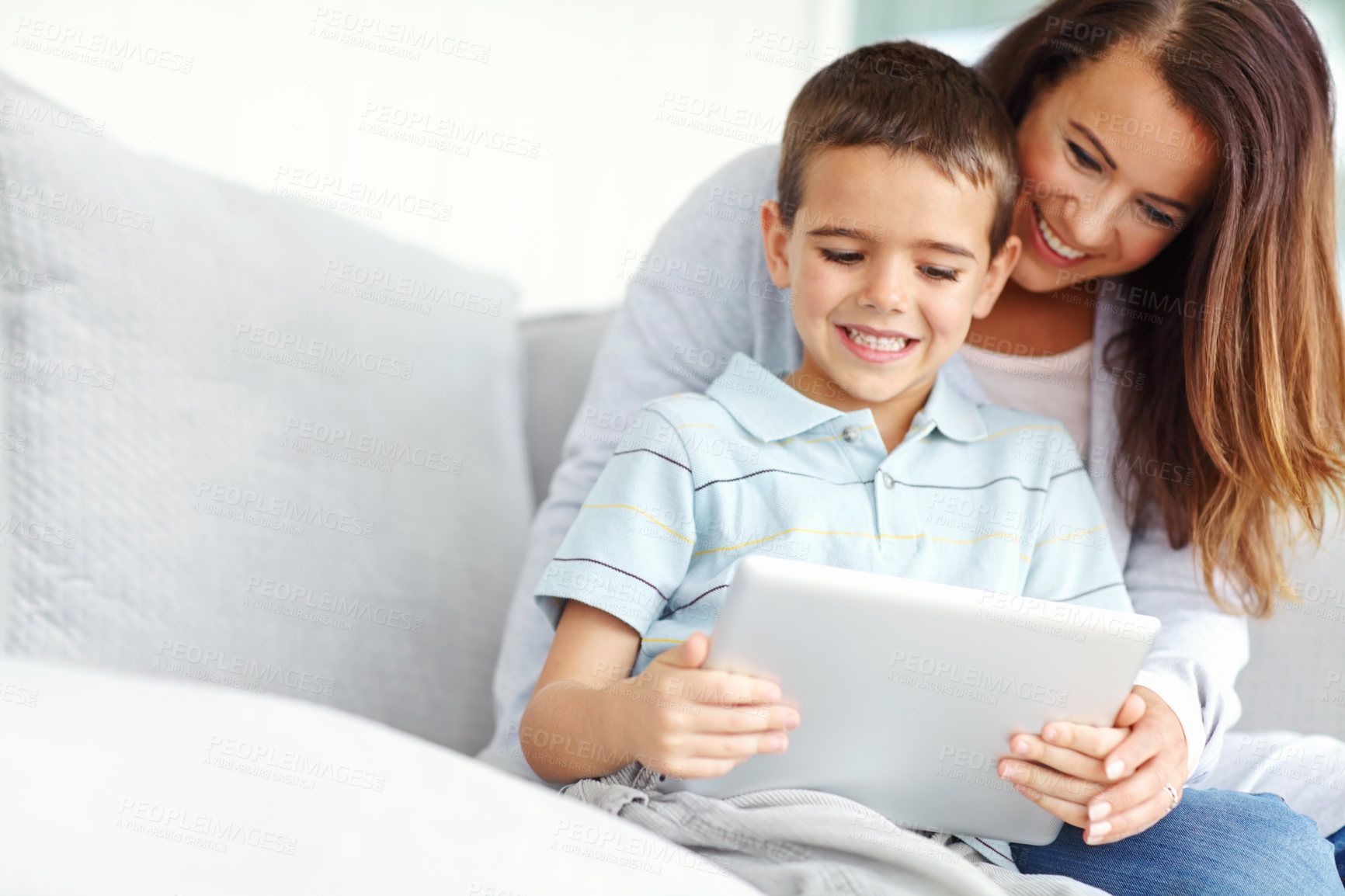 Buy stock photo Mom, child and tablet on sofa for film, online cartoon or internet with entertainment for childhood together at home. Bonding, mother and kid or son with smile with hug and relax on living room couch