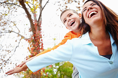 Buy stock photo Mother, son and outdoor with flying on piggyback for fun with bonding, support and care. Low angle, parent and happy or laugh with kid for child development, growth and childhood memories in England