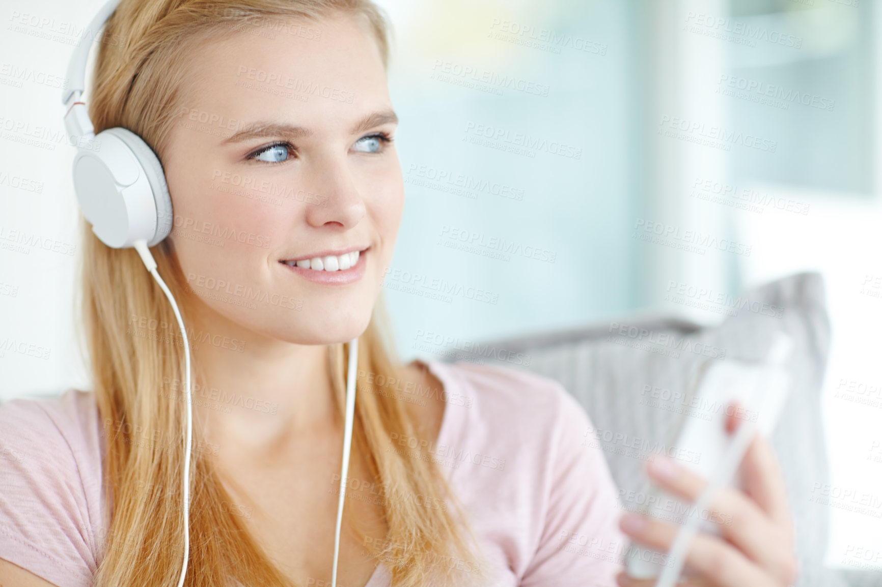 Buy stock photo Headphones, cellphone and woman in home listening to music, song or radio on sofa in living room. Smile, phone and female freelance playlist curator with audio tech for online album review at house.