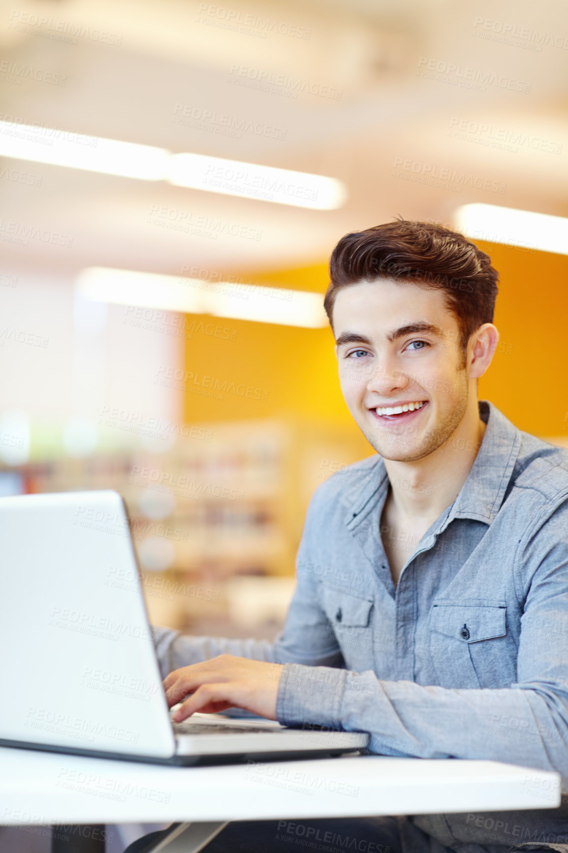 Buy stock photo Laptop, portrait and typing with student man in library on campus of college or university for development. Computer, education and smile with happy person at desk or table for research or study