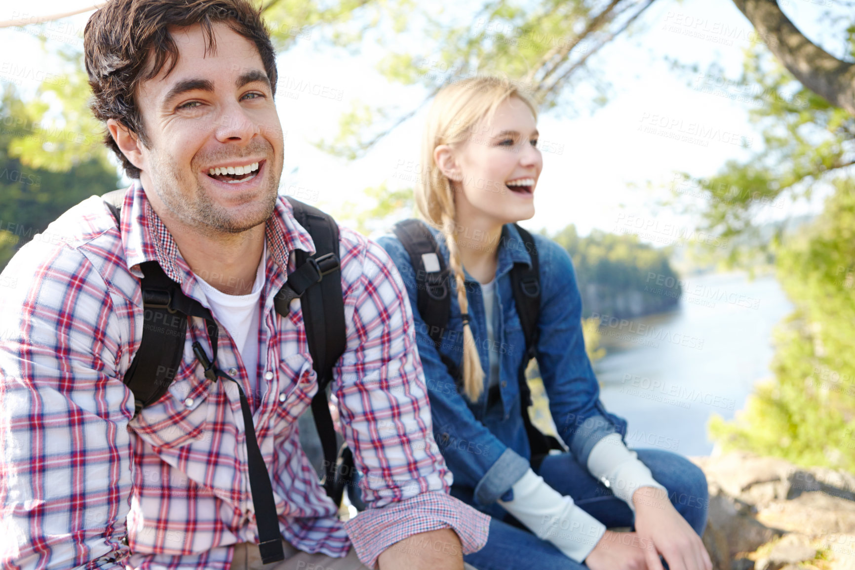 Buy stock photo Portrait, relax or happy couple hiking by river for travel, outdoor adventure or journey in nature with smile. Laugh, resting or people in forest on holiday vacation, fun trip or lake to explore park