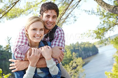 Buy stock photo Portrait, hug or happy couple by river in nature for travel, outdoor adventure or hiking in woods together. Love, forest or people resting to relax on holiday vacation, break or trip to explore park