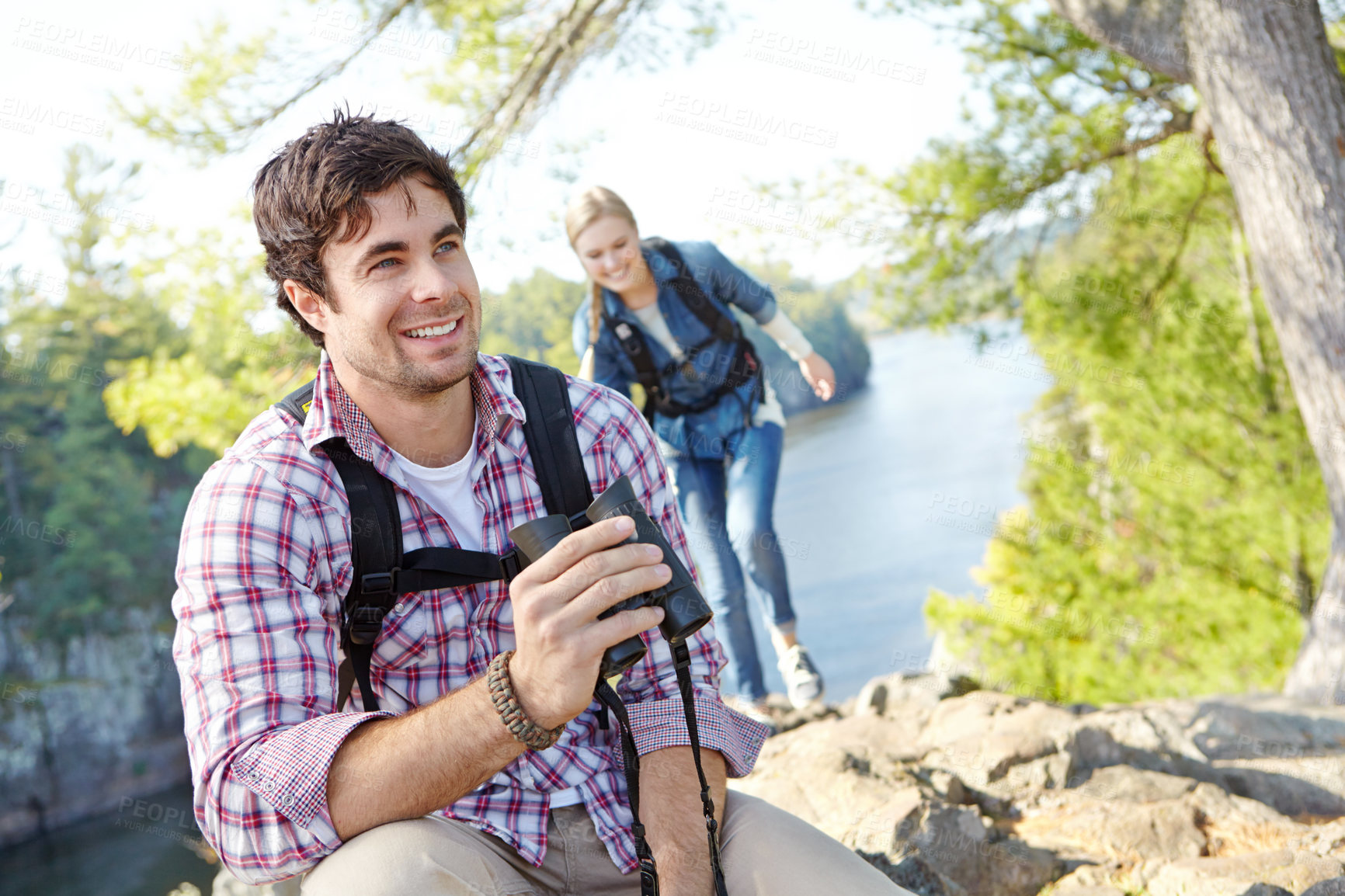 Buy stock photo Happy man, binocular or couple hiking in forest for travel, outdoor adventure or journey in woods. Mountain, view or people sightseeing in nature on holiday vacation, lake or break to explore park