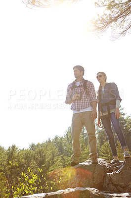 Buy stock photo Peak, binocular or couple hiking in mountain for nature or outdoor adventure in woods or forest. Rock, view or people on hill sightseeing together on holiday vacation, trip or break to explore park