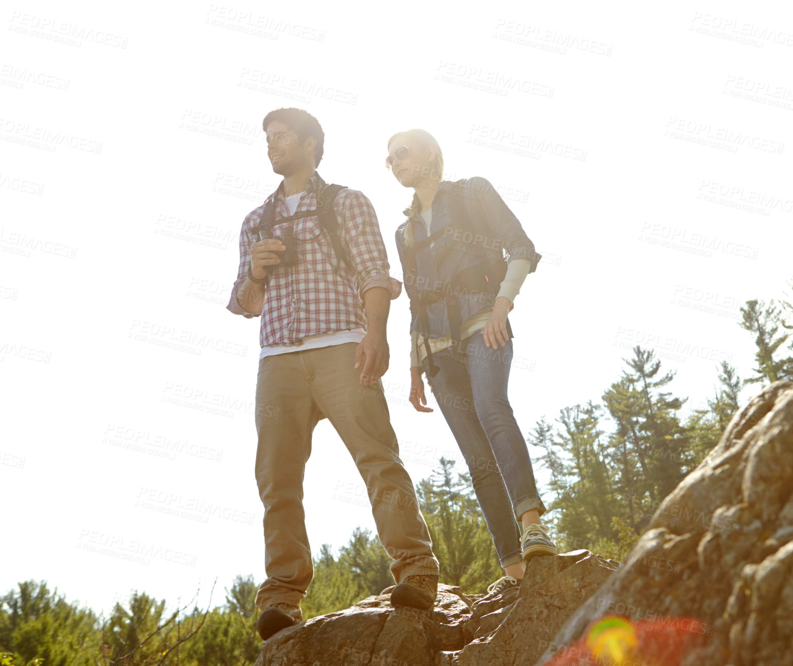 Buy stock photo Peak, rock or couple hiking on mountain for nature or outdoor adventure in woods or forest. Binocular, view or people on hill sightseeing together on holiday vacation, trip or break to explore park