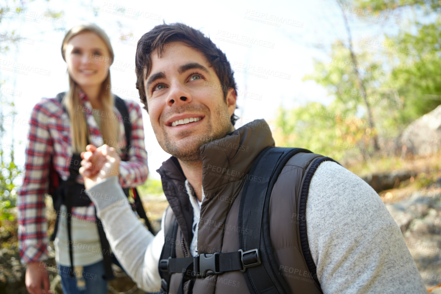 Buy stock photo Smile, helping hand or couple in nature for romantic travel, outdoor adventure or trekking in forest. Happy, support or people in woods walking on holiday vacation, mountain or break to explore park