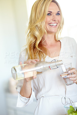 Buy stock photo Woman, glass and pouring water with smile, home or thinking with hydration, wellness or gut health. Person, happy and bottle for liquid, detox and excited with drink, thirsty or beverage at apartment