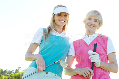 Buy stock photo Two attractive woman holding golf clubs and standing with their golf cart 