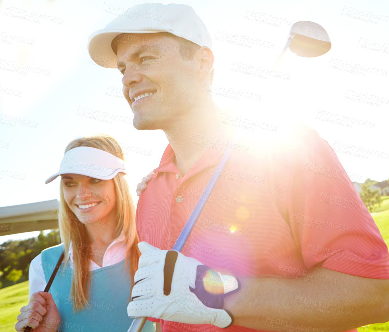 Buy stock photo Golf course, couple and club for holiday, exercise or weekend hobby together on vacation. Lens flare, smile and happy woman with man on green for competition, outdoor challenge and sports turf field