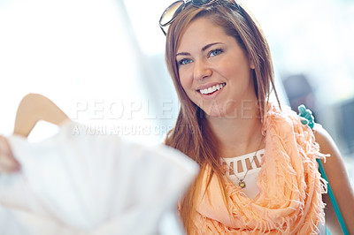 Buy stock photo An attractive young woman browsing the racks in a department store