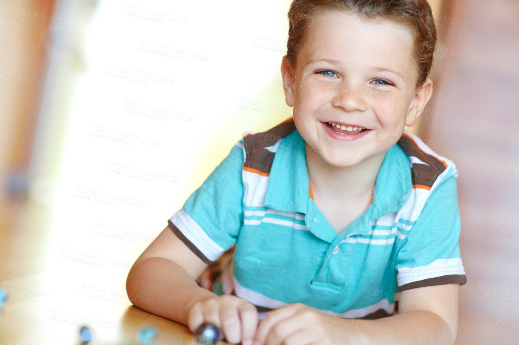 Buy stock photo Floor, boy and happy with playing marbles on portrait for fun on school break at home in Scotland. Male person, kid and smile at apartment with toys for games, child growth and brain development