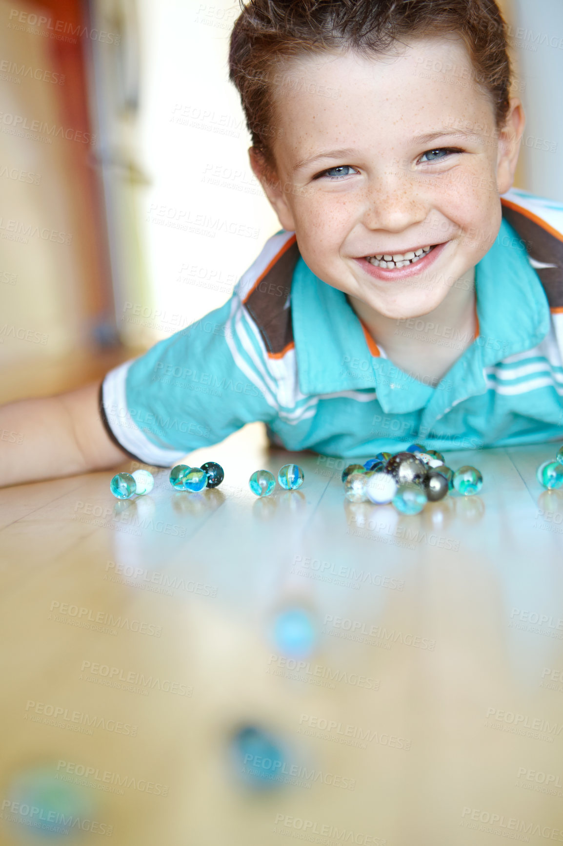 Buy stock photo Home, boy and happy with playing marbles on portrait for fun on school break on floor in Scotland. Male person, kid and smile at apartment with toys for games, child growth and brain development