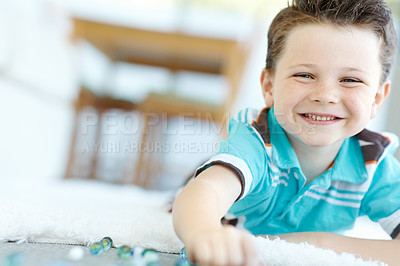 Buy stock photo Happy child, portrait and kid play with marbles on floor for game, relax and fun in home. Smile, face and boy with glass balls or toys on ground for creative collection or childhood development in Uk