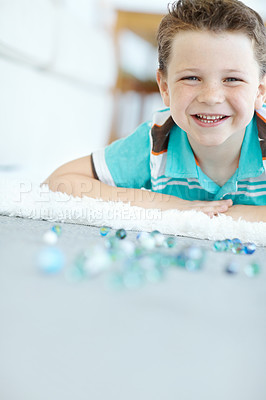 Buy stock photo Smile, kid and portrait of child with marbles on floor for funny game, relax or laugh in home. Face, happy boy and glass balls or toys on carpet for creative collection, playing or development in USA