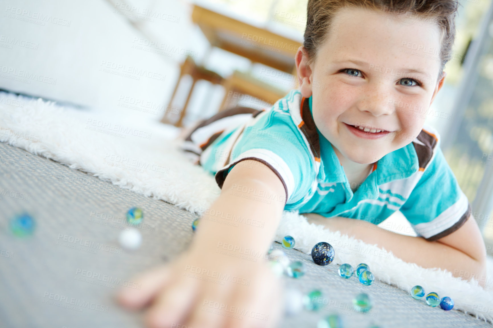 Buy stock photo Happy, portrait and kid play with marbles on floor for funny game or relax in home. Face, smile and cute boy with glass balls or toys on carpet for creative collection, laughing or development in USA