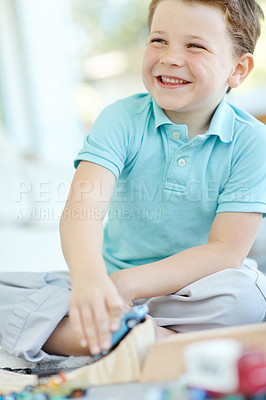 Buy stock photo Laughing, cars and boy in house playing for learning, development and fun with smile. Excited, ramp or child enjoying games with plastic vehicle toys for childhood hobby or growth in home in England