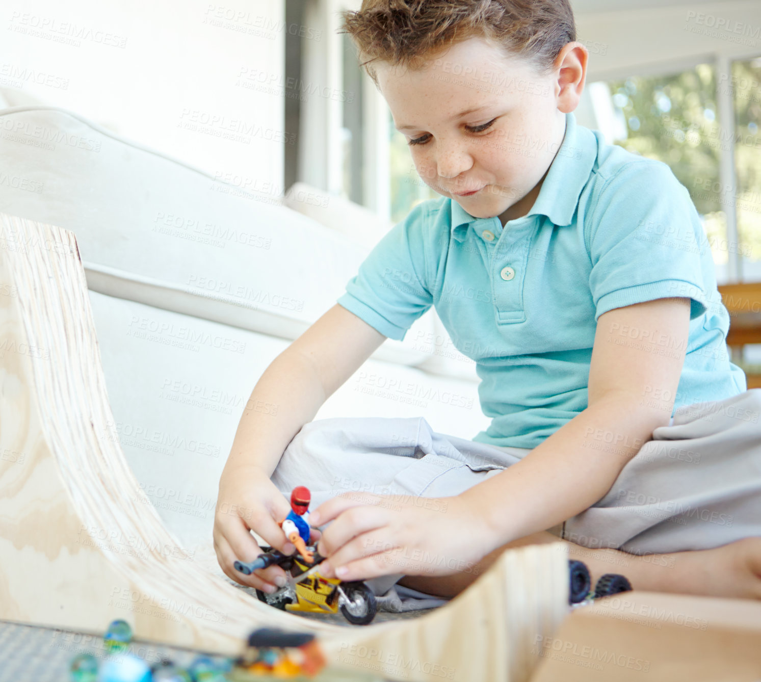 Buy stock photo Bike, toys and boy in home playing for learning, development and fun with smile. Excited, ramp or male child enjoying games with cool plastic figure for childhood hobby or growth at house in England