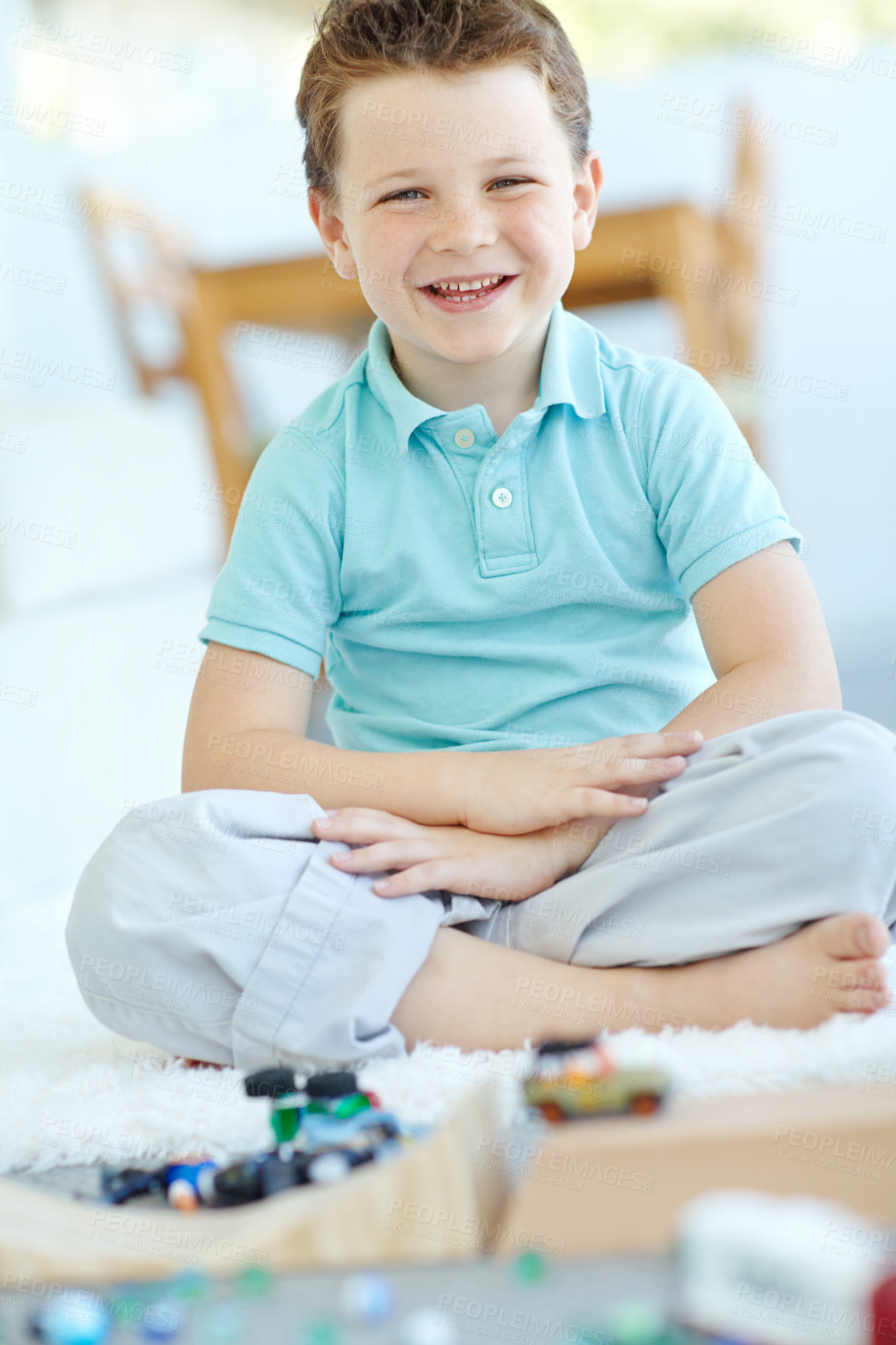 Buy stock photo Home, boy and happy with toy cars on portrait for fun on school break on floor in Scotland. Male person, kid and smile at apartment with playing for child growth, care and brain development at lounge