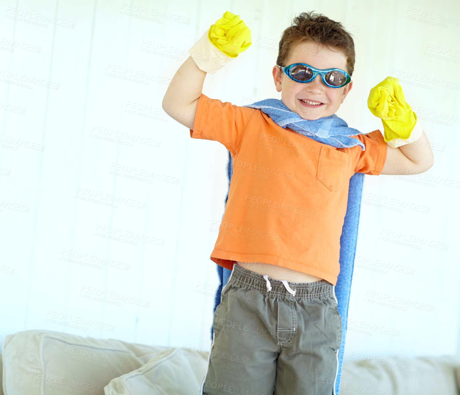 Buy stock photo Flex muscle, child and happy superhero in home to play fantasy game. Smile, cute boy or strong hero with power in costume to fight for justice, courage or creative cosplay in living room on halloween