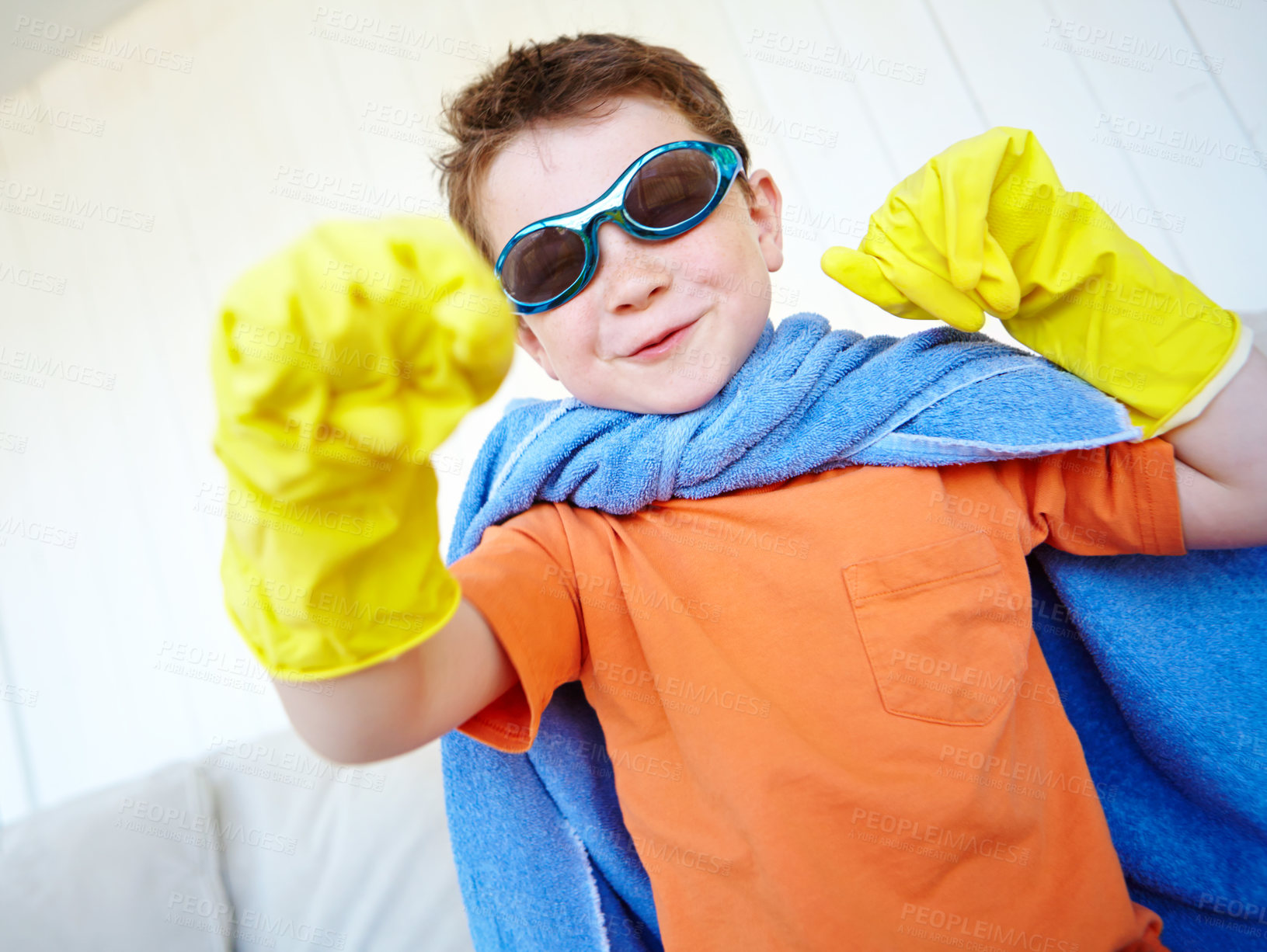 Buy stock photo Fight, kid and happy superhero in home to play fantasy game on halloween. Punch, cute boy and hero with power in creative cosplay costume for justice, courage and confidence in living room on couch