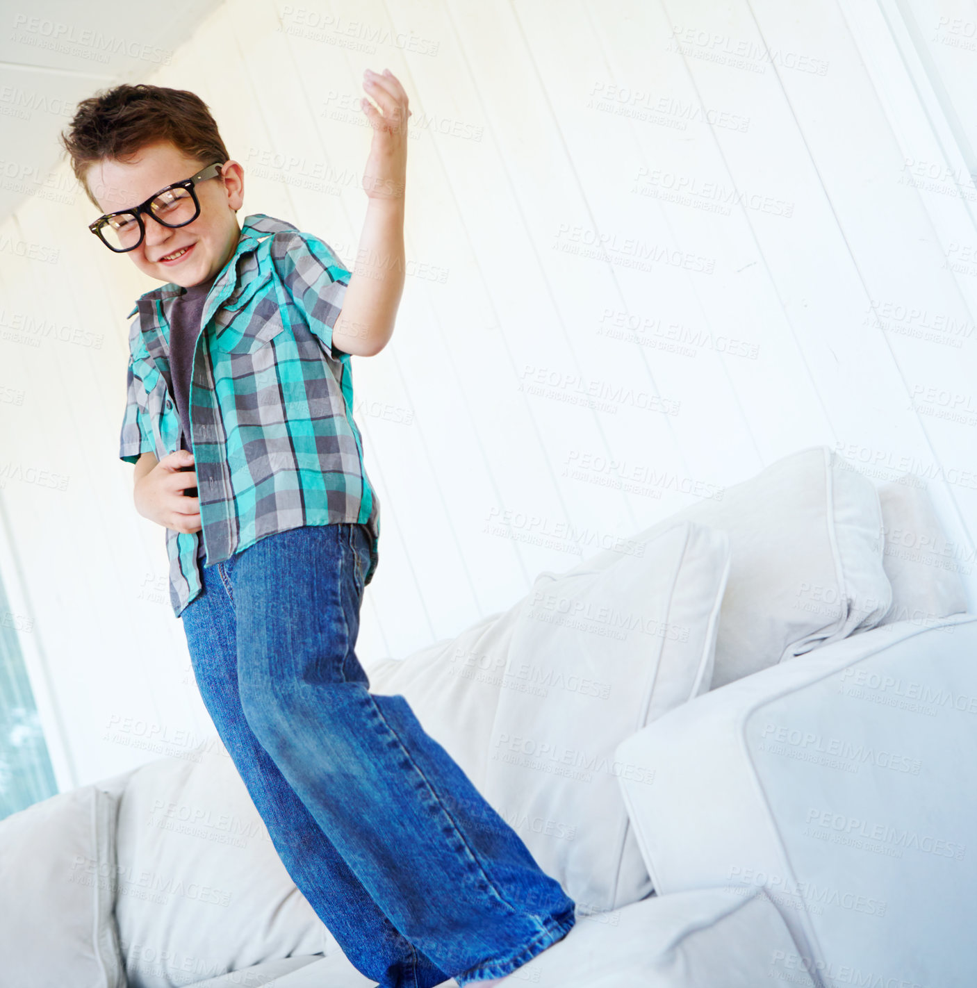 Buy stock photo Dancing, play or kid with air guitar on sofa for comedy, humour or funny joke for rock and roll. Happy, excited or crazy boy child with music, celebration or imaginary instrument on couch in home