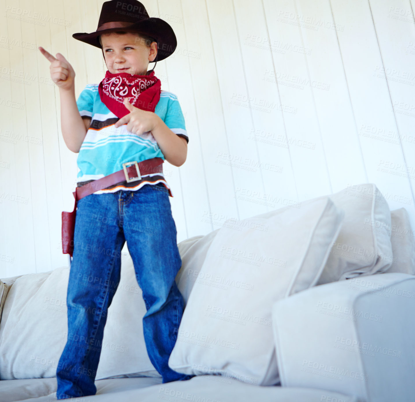 Buy stock photo Kid, cowboy and play game with gun gesture for fantasy and creative cosplay in home living room. Boy child, western costume and pistol fingers on sofa for shooting, pretend or dress up for halloween