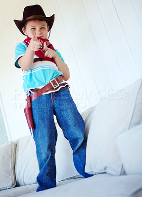 Buy stock photo Kid, boy and portrait with cowboy costume on sofa for fantasy play, shooting game or pointing pretend gun. Person, smile or hand gesture in home for halloween, dress up or protection with imagination