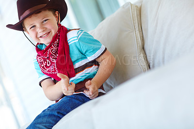 Buy stock photo Happy child, cowboy portrait and play with gun gesture for fantasy, game or creative cosplay in home. Kid boy, western costume and pistol fingers on sofa for shooting or dress up on halloween in USA