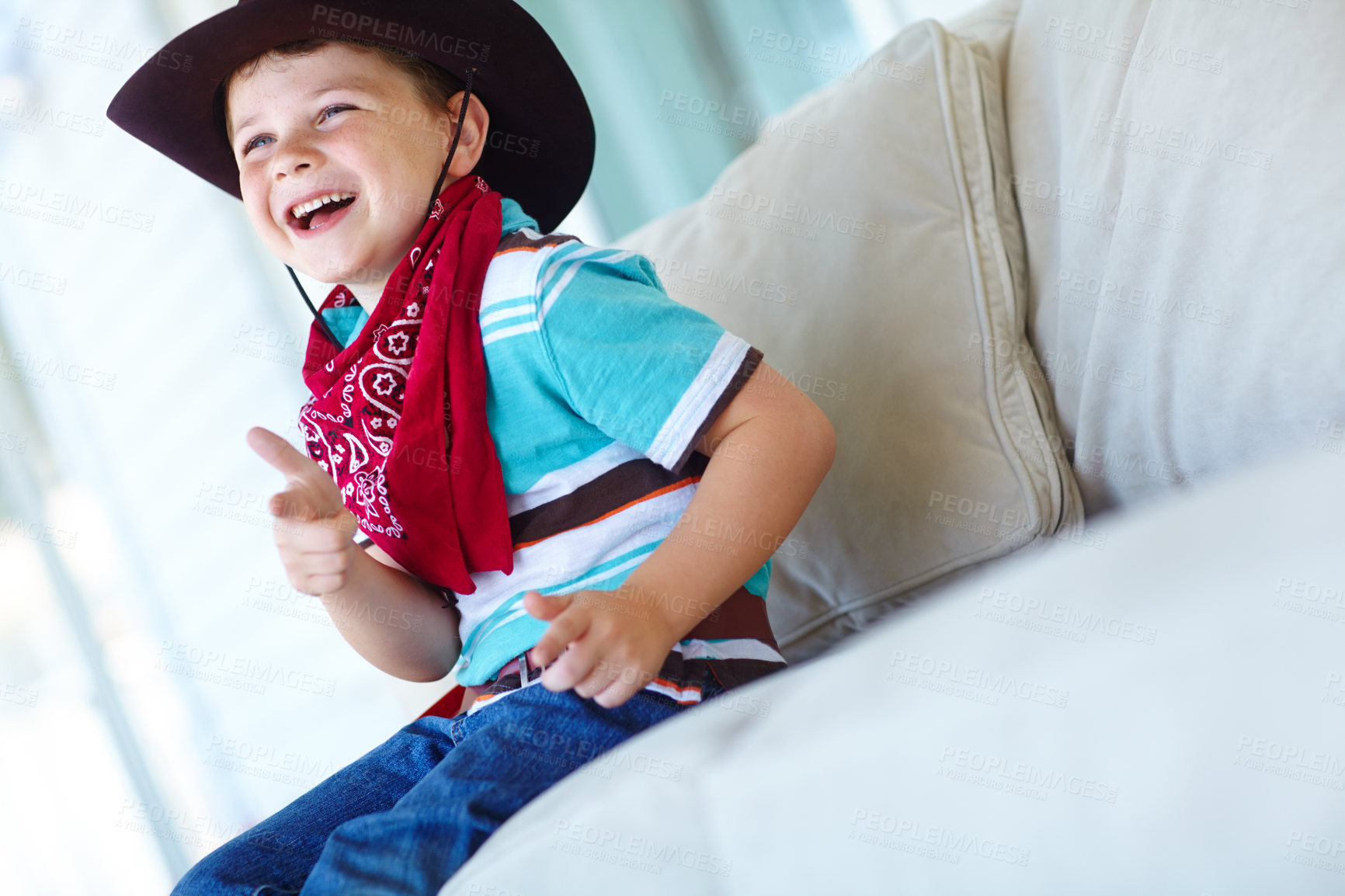 Buy stock photo Boy, child and cowboy fashion in home, fantasy games and imagine western culture in living room. Male person, kid and finger gun with costume for adventure, laughing and emoji for playing dress up